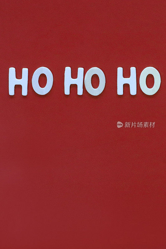 自制DIY简易圣诞贺卡设计的图像，红色背景上剪出白色字母，手工制作的节日圣诞贺卡，Ho Ho Ho留言，复制空间